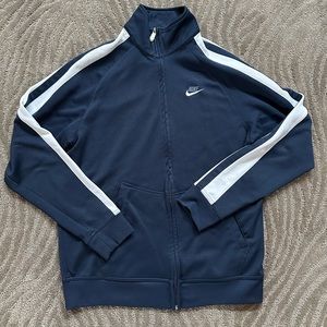 Nike navy track jacket with dual stripes running down the arms